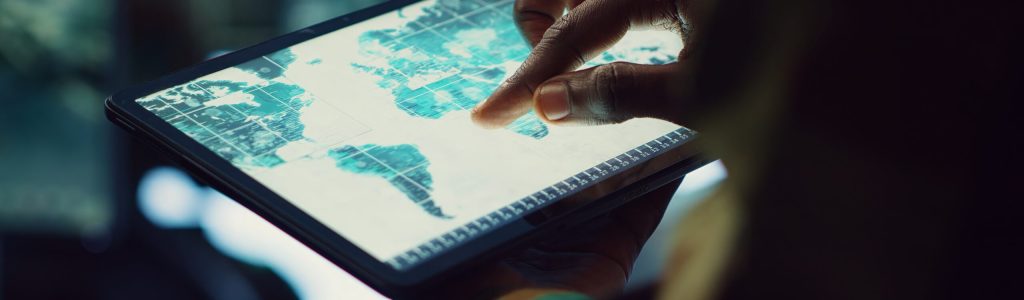 Military IT professional gathers intelligence from world map projection, tablet connected to satellite reconnaissance system to support field troops. Dispatch army command post. Close up. Camera A.